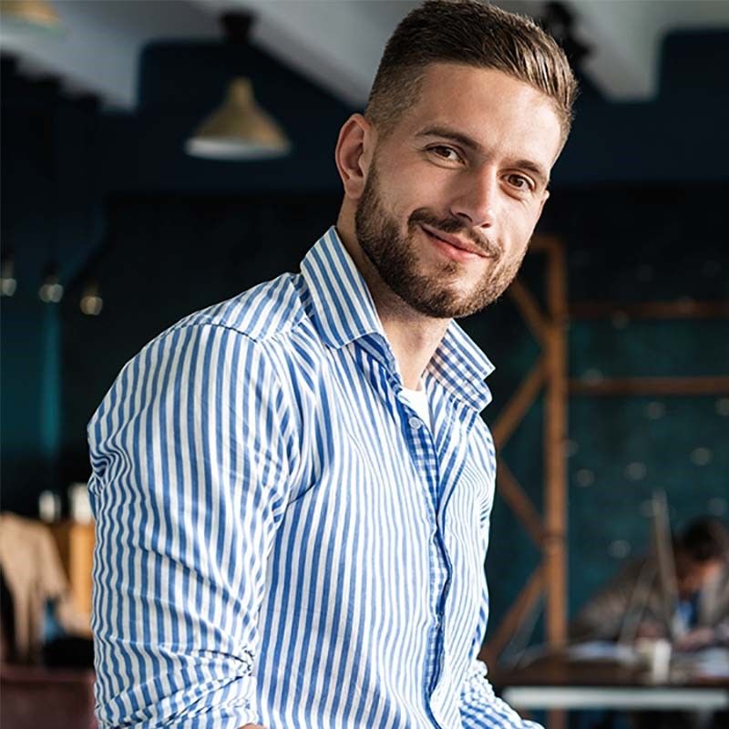 Zufrieden schauender Mann, der in der All-Finanz-Beratung tätig ist.
